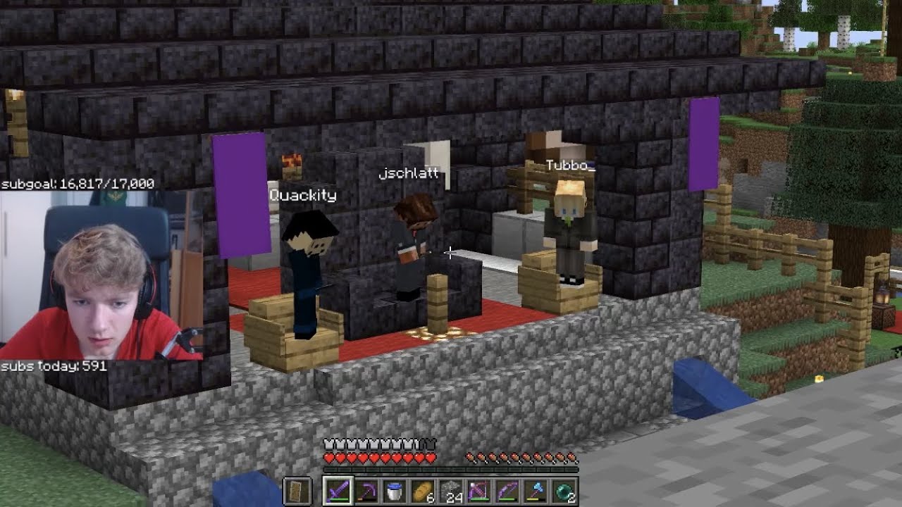 A screenshot from Tommy's stream. Quackity, Schlatt and Tubbo all stand on the Manburg stage in suits and in their respective seats. Schlatt is talking in the microphone in the center. Tommy's camera shows him leaning forwards towards his screen with a concerned look on his face.